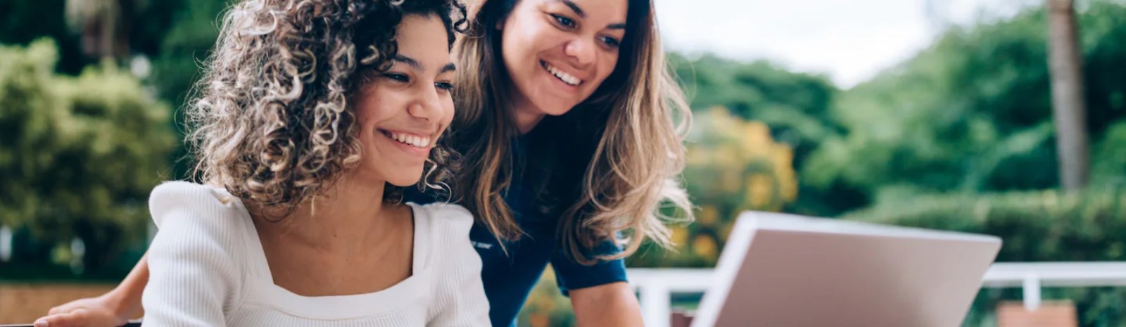 a mother and daughter looking at a laptop