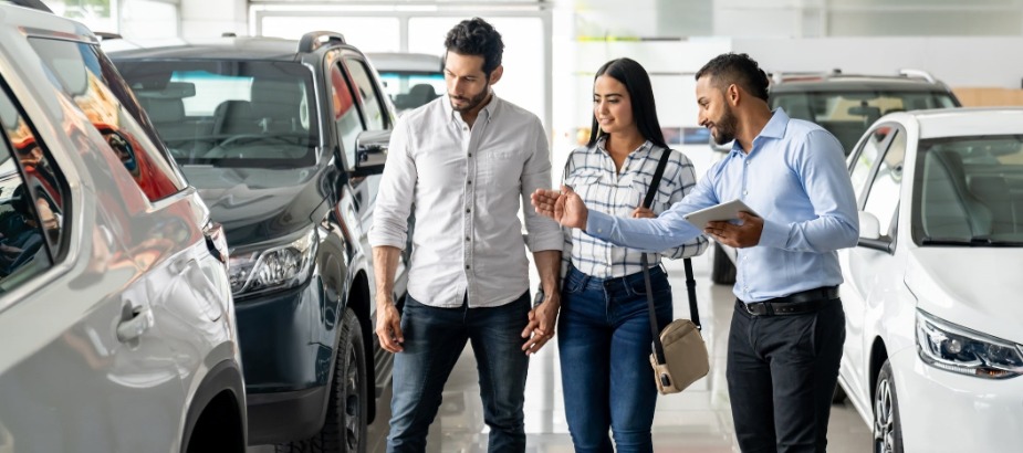 a couple shopping for a new vehicle being assistant by a representative