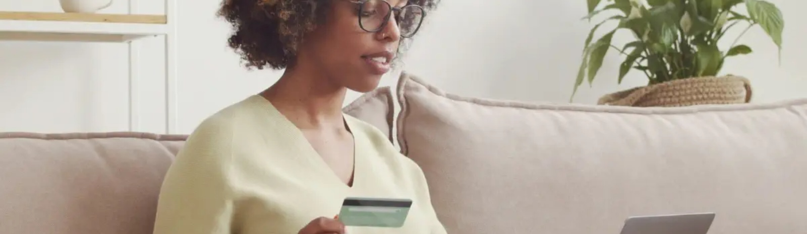 a woman sitting on a couch making an online purchase