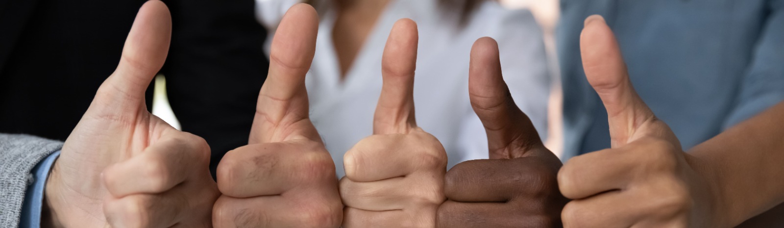 five people with their thumbs up