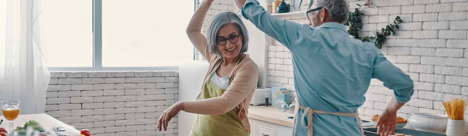an elderly couple dancing in a kitchen