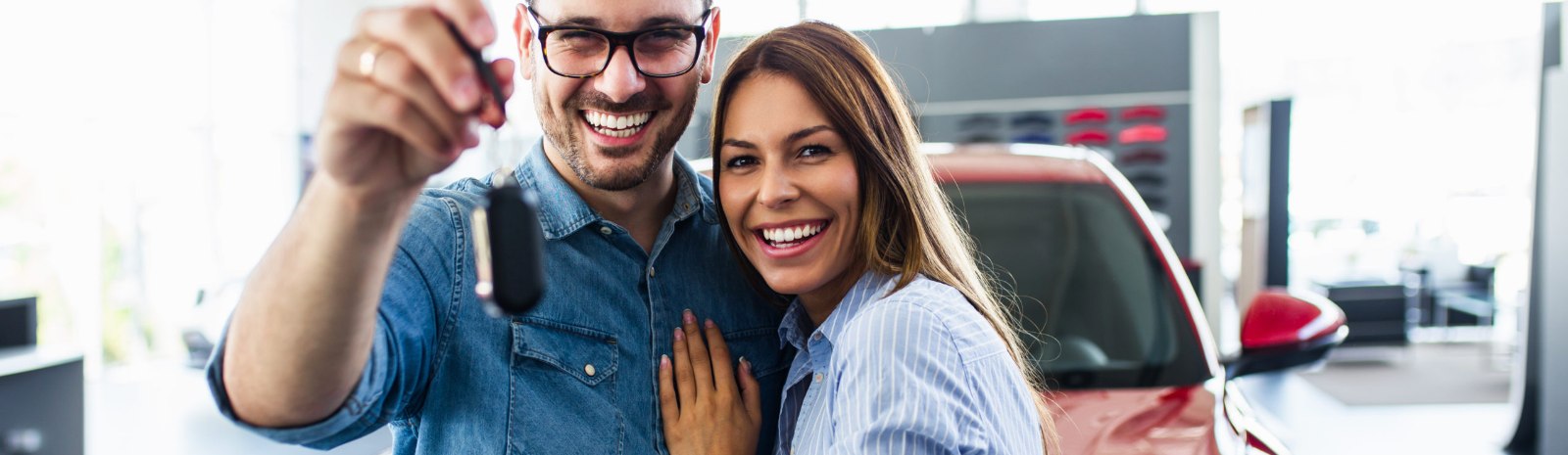a couple holding keys to a new vehicle